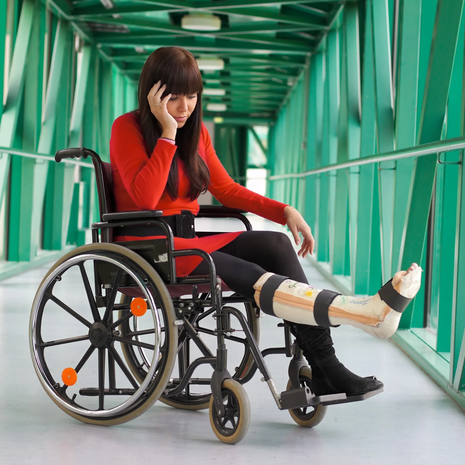 Vrouw zit in rolstoel met gebroken been